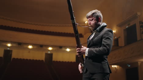 handsome-bearded-man-is-playing-bassoon-in-music-hall-concert-or-rehearsal-of-symphonic-orchestra