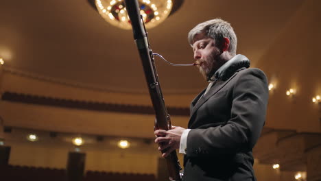bassoonist-is-playing-in-old-music-hall-or-opera-house-man-with-bassoon-on-scene