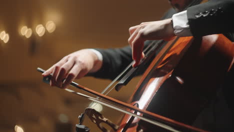 Talentierter-Mann-Spielt-Cello-Auf-Der-Bühne-Des-Alten-Opernhauses,-Nahaufnahme-Der-Hände-Des-Cellisten