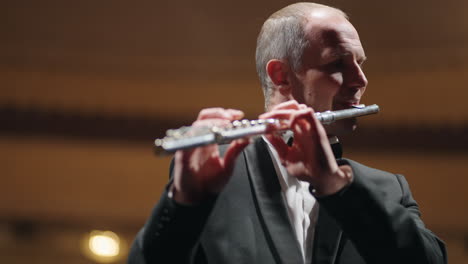 professional-musician-is-playing-flute-in-opera-house-or-philharmonic-hall-portrait-of-flutist-in-orchestra