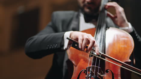 inspired-musician-is-playing-cello-in-opera-house-hall-rehearsal-or-concert-of-classical-music-closeup-view