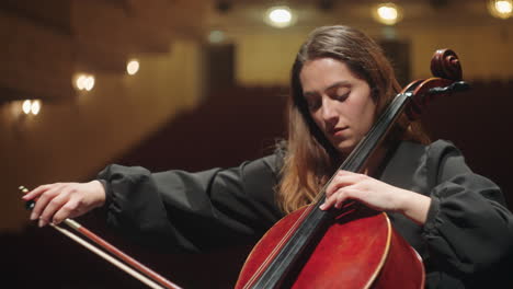 Einsame-Frau-Spielt-Cello-In-Der-Musikhalle-Bei-Proben-Oder-Einem-Konzert-Klassischer-Musik