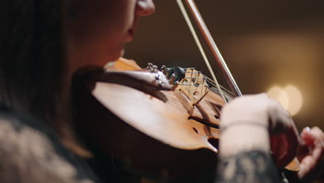 closeup-of-old-violin-in-hands-of-woman-female-musician-is-playing-violin-and-rehearsing-sonata-in-music-hall