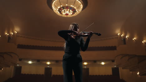 portrait-of-young-woman-with-violin-in-opera-house-fiddler-is-playing-violin-in-music-hall