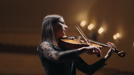 brunette-woman-is-playing-violin-in-philharmonic-hall-female-musician-in-symphonic-orchestra