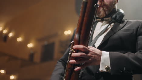 adult-man-with-bassoon-is-playing-music-on-scene-of-old-music-hall-classic-music-concert-in-opera-house