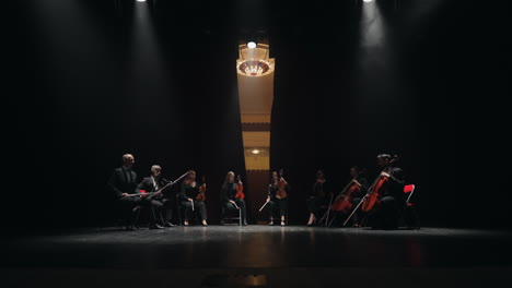 Octeto-De-Músicos-De-Instrumentos-De-Cuerda-Y-Viento-Están-Sentados-En-La-Escena-De-La-Antigua-ópera