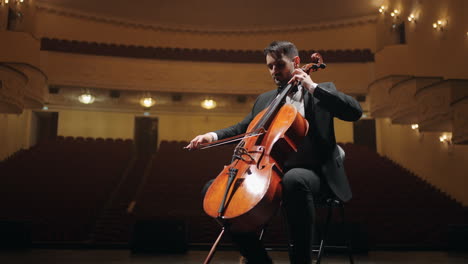 talented-violoncellist-is-rehearsing-on-scene-of-empty-old-opera-house-portrait-of-cellist-in-philharmonic-hall