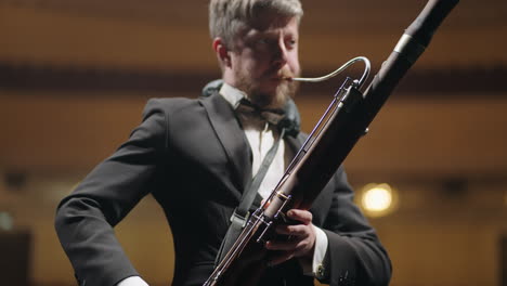 bassoonist-in-music-hall-musician-is-playing-bassoon-on-scene-of-theatre-or-concert-hall