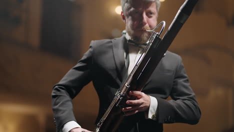 man-with-bassoon-is-playing-music-in-scene-of-classical-music-hall-musician-in-black-suit