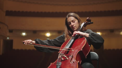 charming-female-musician-is-playing-cello-in-music-hall-female-cellist-is-rehearsing-on-scene