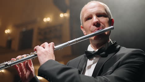 Talentoso-Flautista-De-Pelo-Gris-Está-Tocando-Música-Con-Flauta-En-La-Orquesta-Sinfónica-De-La-ópera