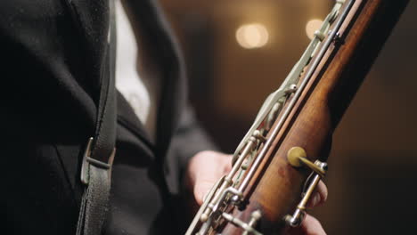 old-bassoon-in-hands-of-musician-closeup-view-symphonic-or-brass-orchestra-talented-bassoonist