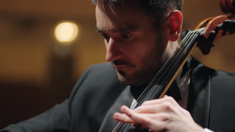 dark-haired-man-is-playing-cello-on-scene-in-opera-house--rehearsal-or-concert-portrait-of-cellist