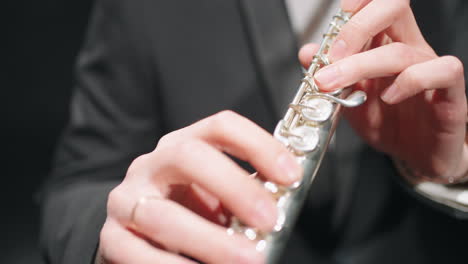 flute-in-hands-of-flutist-closeup-view-musician-in-orchestra-brass-band-on-rehearsing-or-concert