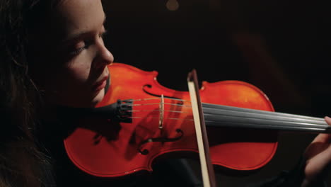 Talentierte-Frau-Mit-Roter-Geige-Spielt-Im-Symphonieorchester-Auf-Der-Bühne-Des-Music-Hall-Porträts
