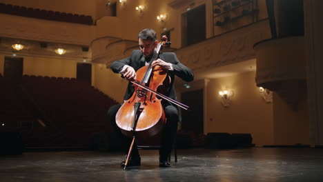 solo-of-violoncellist-on-scene-of-old-opera-house-portrait-of-cellist-in-empty-philharmonic-hall