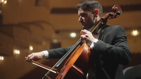 handsome-cellist-is-playing-classic-music-on-scene-of-opera-house-concert-or-rehearsal