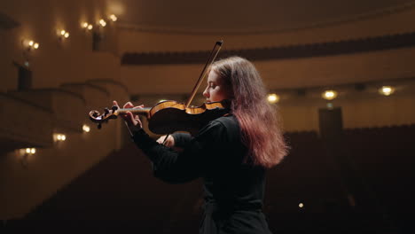 portrait-of-pretty-female-violin-player-in-opera-house-woman-violinist-is-playing-fiddle-in-music-hall