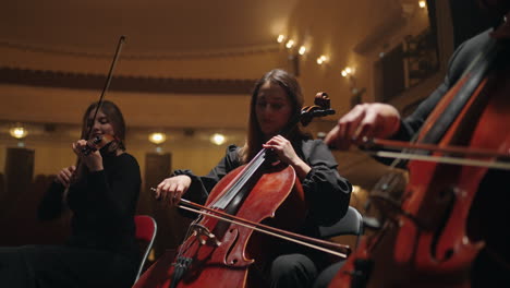 violoncellists-and-violinists-are-playing-music-on-scene-of-philharmonic-hall-string-instruments