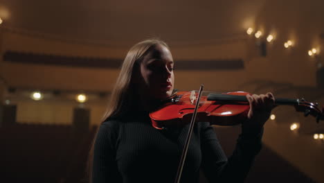 beautiful-woman-is-playing-red-violin-in-symphonic-orchestra-in-opera-house-classic-music-concert