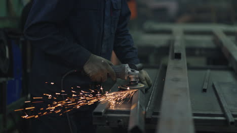 Close-up:-A-man-in-goggles-works-with-metal-grinding-polishing-and-stripping-steel-metal-structures.
