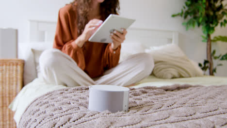 Close-up-view-of-smart-speaker-on-the-bed