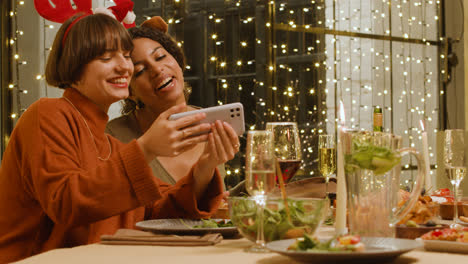 Dos-Mujeres-Divirtiéndose-En-La-Cena-De-Navidad