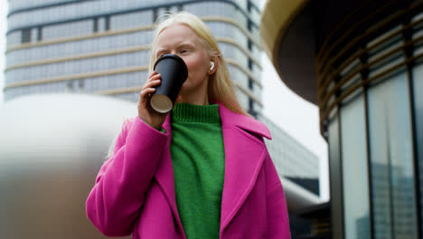 Happy-woman-holding-coffee-cup-outdoors