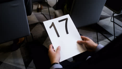 Man-holding-board-with-number-17