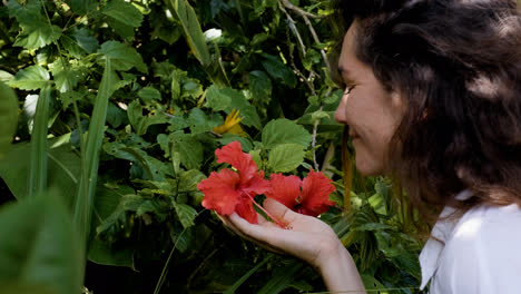 Woman-smelling-red-flower