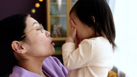 Madre-Asiática-Sosteniendo-A-Su-Bebé