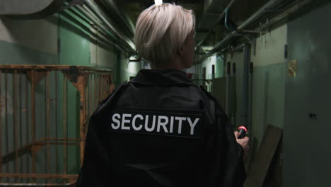 Guardia-De-Seguridad-Femenina-Con-Linterna-En-Un-Almacén