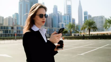 Elegant-businesswoman-with-phone-outdoors