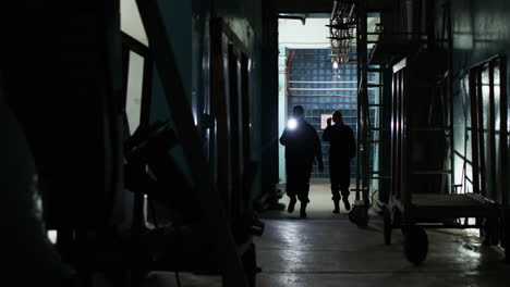 Weibliche-Sicherheitskräfte-Mit-Taschenlampe-In-Einem-Lagerhaus
