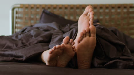 Nackte-Füße-Auf-Dem-Bett