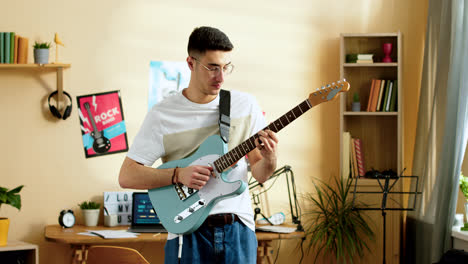 Young-man-practising-with-the-guitar