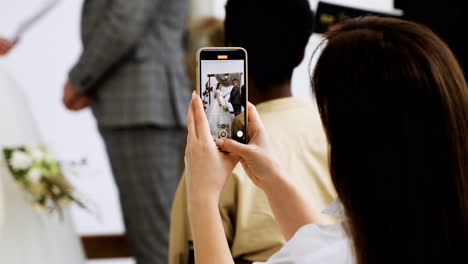 Guest-using-smartphone-at-the-ceremony