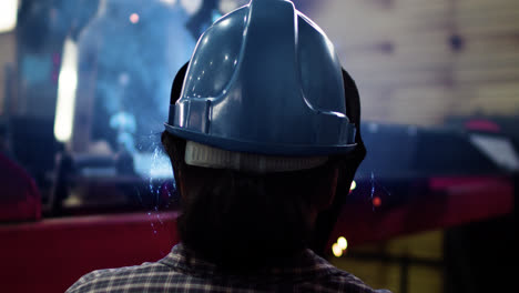 Worker-with-welding-helmet-in-factory