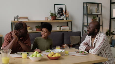 Black-men-and-boy-eating-lunch-at-home