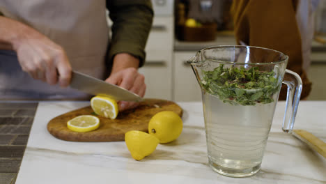 Man-cutting-ingredients-to-make-limonade