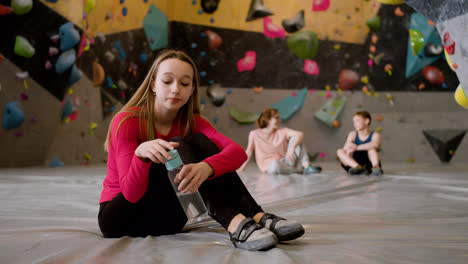 Teenage-girl-drinking-water-in-a-climbing-gym