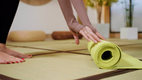 Person-putting-yoga-mat-on-the-floor