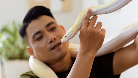 Man-holding-snake-indoors