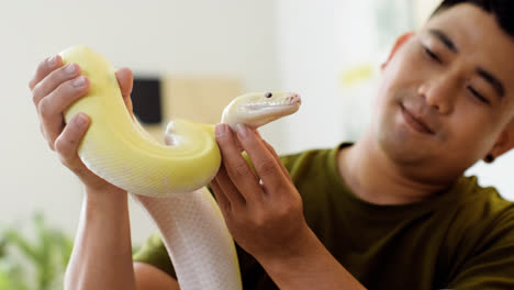 Man-holding-snake-indoors