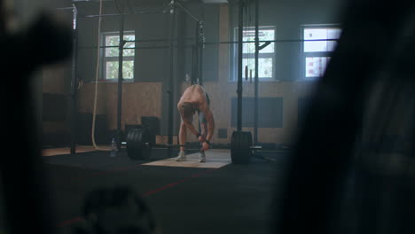 Young-man-doing-the-clean-and-jerk-weightlifting-exercise-at-the-gym.-Man-doing-deadlift-exercise-at-gym.-Young-athlete-lifts-barbell-to-his-chest.-Male-weightlifter-lifting-a-barbell-at-a-competition