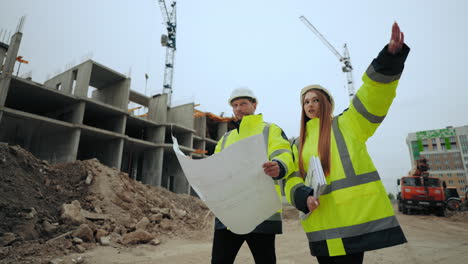 man-and-woman-are-walking-in-building-site-foreman-and-female-building-inspector-are-checking-construction-plan