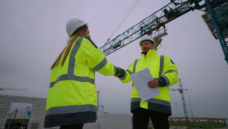 female-civil-engineer-and-foreman-are-shaking-hands-in-construction-site-woman-architect-and-builder