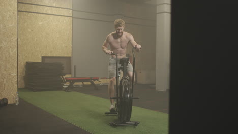 Fitness-man-on-bicycle-doing-spinning-at-gym.-Fit-young-male-working-out-on-gym-bike.-Male-exercising-on-bicycle-in-health-club