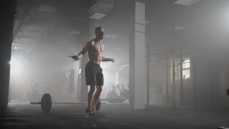 Young-man-exercising-using-skipping-rope-in-gym.-Athletic-man-training-hard-at-the-gym.